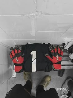 two pairs of feet wearing red and black gloves