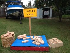 there is a sign that says lumber yard next to some boxes and crates on the grass