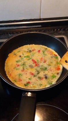 an omelet is cooking in a pan on the stove