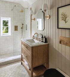 a bathroom with a sink, mirror and shower