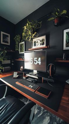 a desk with a computer, keyboard and mouse on it in front of a potted plant