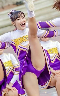 a group of cheerleaders in purple and white outfits