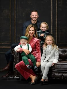 a family posing for a photo in front of a black background