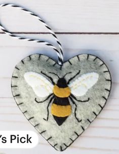 a heart shaped ornament with a bee on it