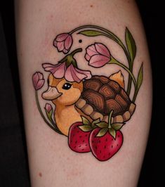 a tattoo with flowers and a turtle on it