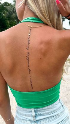 the back of a woman's neck with writing on her left shoulder and right arm