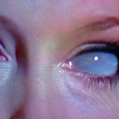 a woman's blue eye is seen through the screen in this close up photo