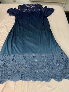 a blue dress laying on top of a white bed