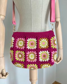 a crocheted purse is displayed on a mannequin