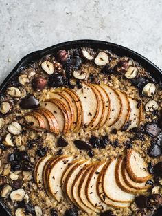 baked oatmeal with sliced apples and raisins in a cast iron skillet