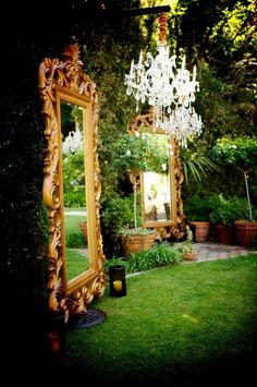 a large mirror sitting on top of a lush green field