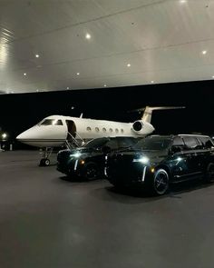 a black car parked in front of an airplane and a white plane on the ground