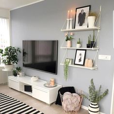 an instagramted photo of a living room with grey walls and white furniture