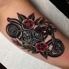 a tattoo with a motorcycle and flowers on it