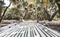 an outdoor wedding venue with white and green striped carpeting, chandeliers and tables