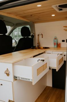 the interior of a camper van with drawers and cupboards in place for storage