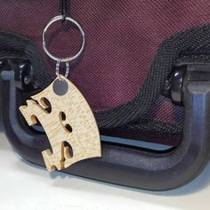 a wooden keychain hanging from the side of a piece of luggage