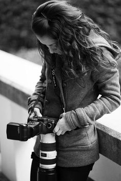 black and white photograph of a woman holding a camera