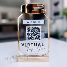 a glass jar with a qr code on it sitting on top of a table