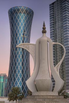 a large white sculpture in front of some tall buildings