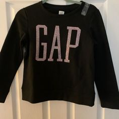 Long-Sleeved Gap In Glitter Long Sleeve Cotton Tops With Glitter Print, Black Glitter Long Sleeve Top, Crew Neck Top With Glitter Print For Fall, Glitter Print Crew Neck Tops For Fall, Glitter Long Sleeve Tops For Winter, Long Sleeve Glitter Tops For Winter, Black Cotton Top With Glitter Print, Long Sleeve Glitter Top For Winter, Glitter Long Sleeve Winter Tops