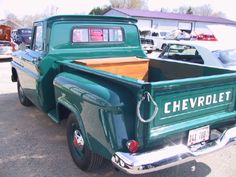 an old chevrolet pick up truck parked in a parking lot