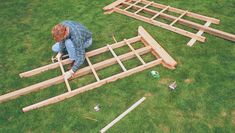 a man working on some wooden structures in the grass