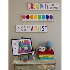 there are three signs on the wall above a dresser and a small table in front of it