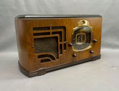 an old fashioned wooden radio sitting on top of a table