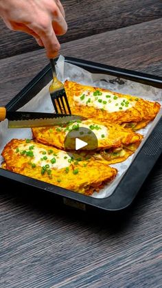 someone is cutting up some food on a tray with a fork and knife in it