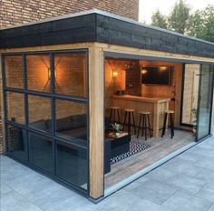 an outdoor bar with stools and barstools in front of a brick building