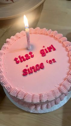 a pink birthday cake with the words that girl since or written on it and a lit candle