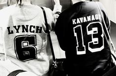 two young men sitting next to each other in front of a wall with the number thirteen on it