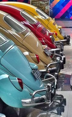 a row of cars parked next to each other in a room filled with colorful walls