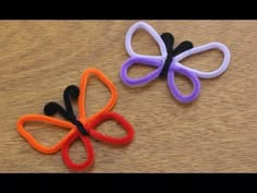 two different colored hair clips sitting on top of a wooden table next to each other