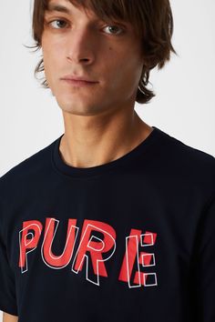 a young man wearing a black shirt with the word pure printed on it