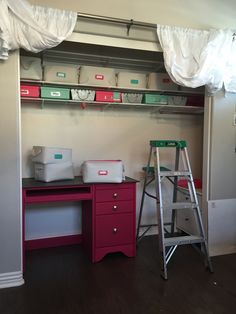 a room with shelves, drawers and a ladder on the wall next to a desk