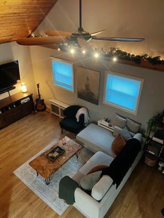 an overhead view of a living room with couches, coffee table and ceiling fan