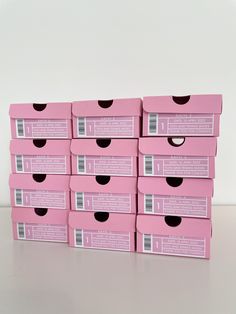 six pink boxes are stacked on top of each other with black holes in the middle