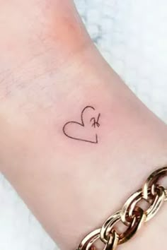 a small heart tattoo on the wrist