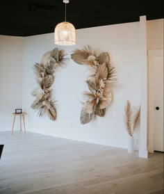 an empty room with white walls and two large feathers hanging on the wall next to each other