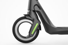 an electric scooter is shown on a white background with green light coming from the front wheel