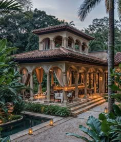 an outdoor dining area in the middle of a tropical garden