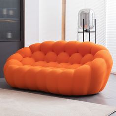 an orange couch sitting on top of a white rug