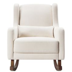 an upholstered white chair with wooden legs and arm rests against a white background