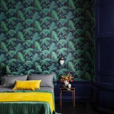 a bedroom with green and yellow wallpaper in the corner, along with a bed