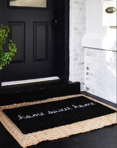 a welcome mat on the front steps of a house with a potted plant next to it