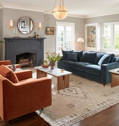 a living room filled with furniture and a fire place in the middle of a room