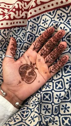 a woman's hand with henna tattoos on it and a heart drawn on the palm