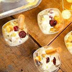 four desserts in plastic containers on a wooden table